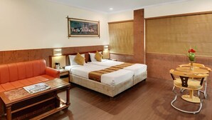 Una habitación de hotel con una cama, un sofá, una mesa y una silla.