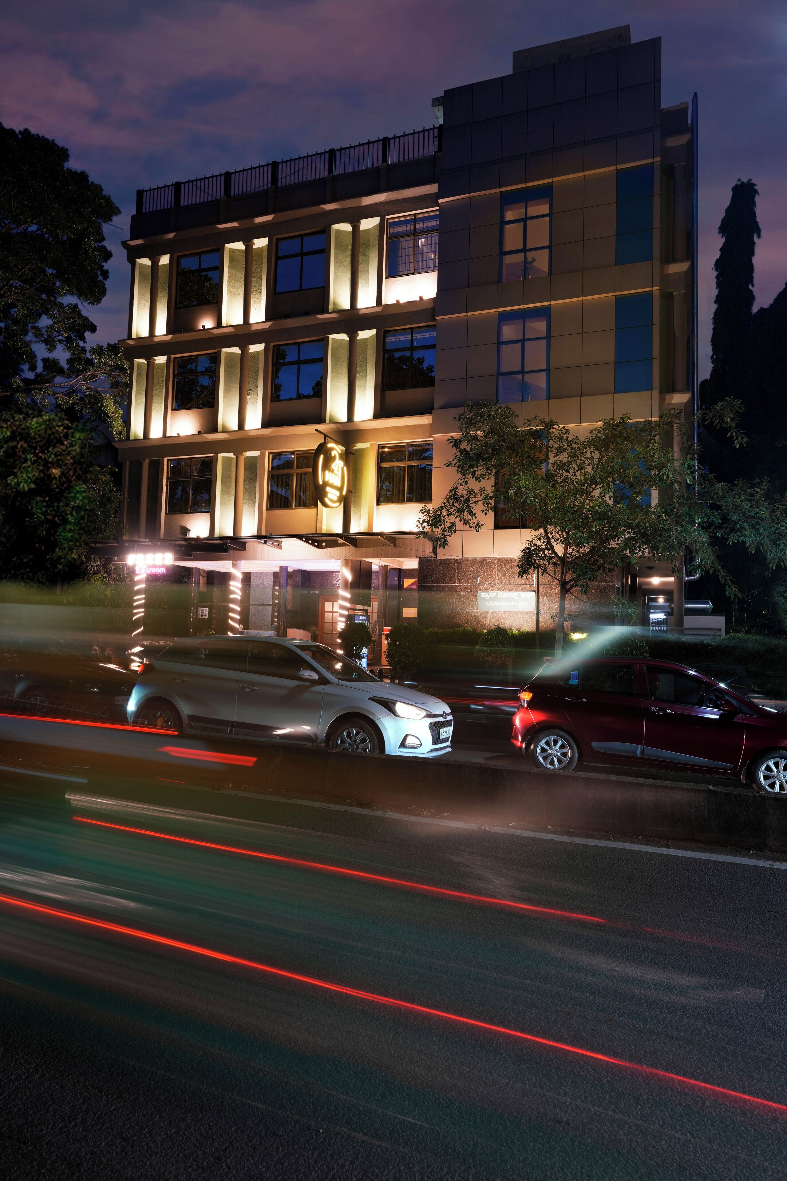 A multi-story hotel with illuminated windows and a well-lit entrance.