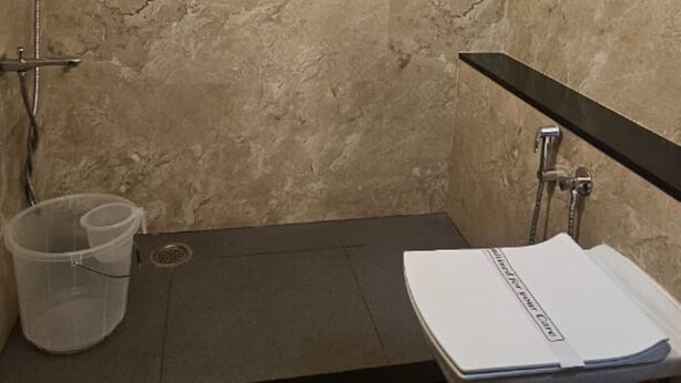 A bathroom with a shower, a toilet, and a sink.