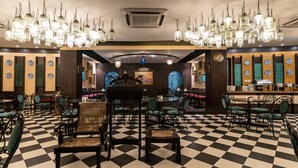 A restaurant with a checkered floor, hanging lanterns, and traditional decor. - The Lindsay (Kolkata)