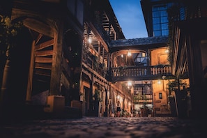 A cobblestone street with traditional European architecture, including balconies and wooden beams. - Cour du Corbeau Hotel Strasbourg - MGallery Collection (Strasbourg)