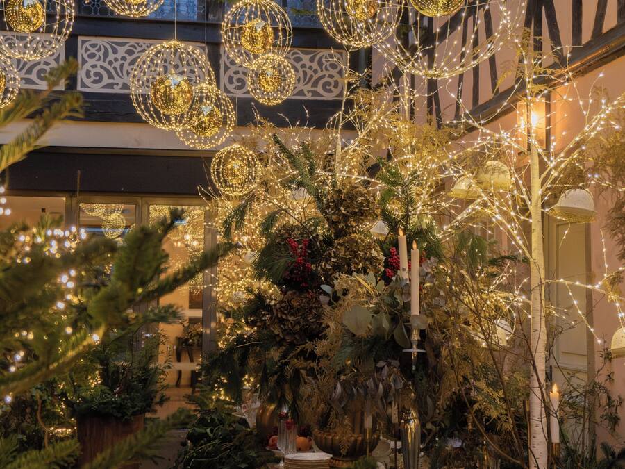 Une cour intérieure agrémentée de luminaires sphériques suspendus et d’une variété de plantes.