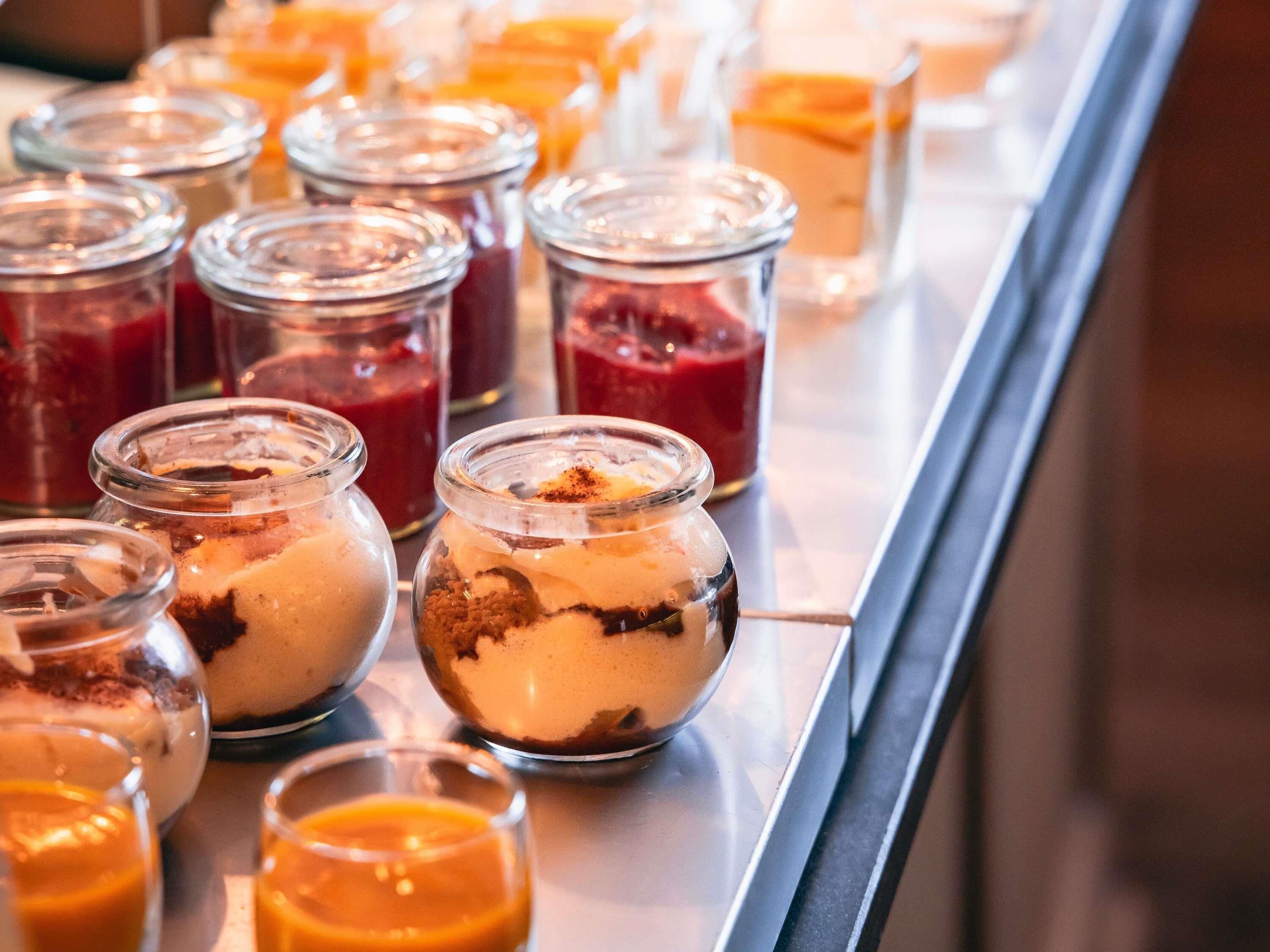 A buffet with various food items in glass containers.