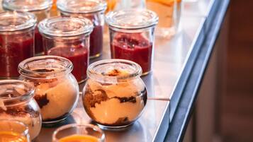A buffet with various food items in glass containers.