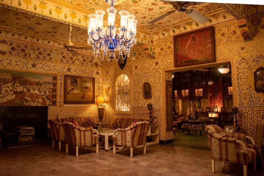 Une pièce richement décorée, avec un lustre, des murs à motifs et des meubles de style traditionnel.