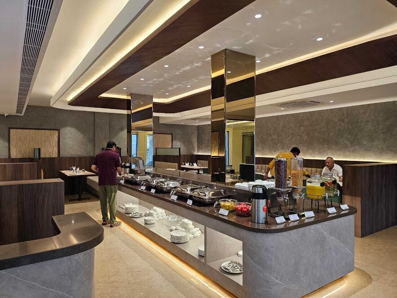 Una barra de desayuno moderna con diversas opciones de comida, como frutas, cereales y bebidas, en un ambiente contemporáneo y bien iluminado.