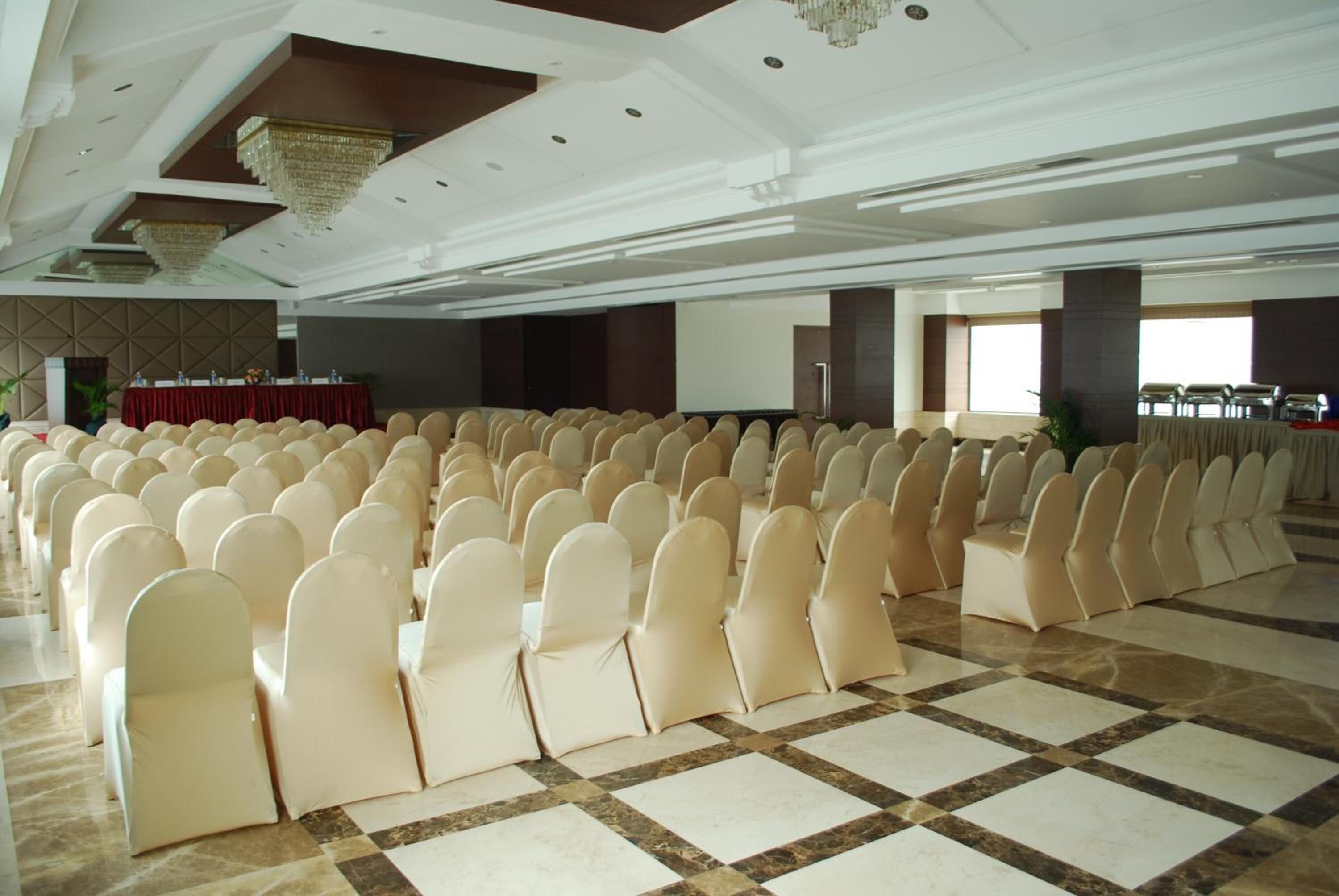 Une grande salle avec des rangées de chaises et une scène.