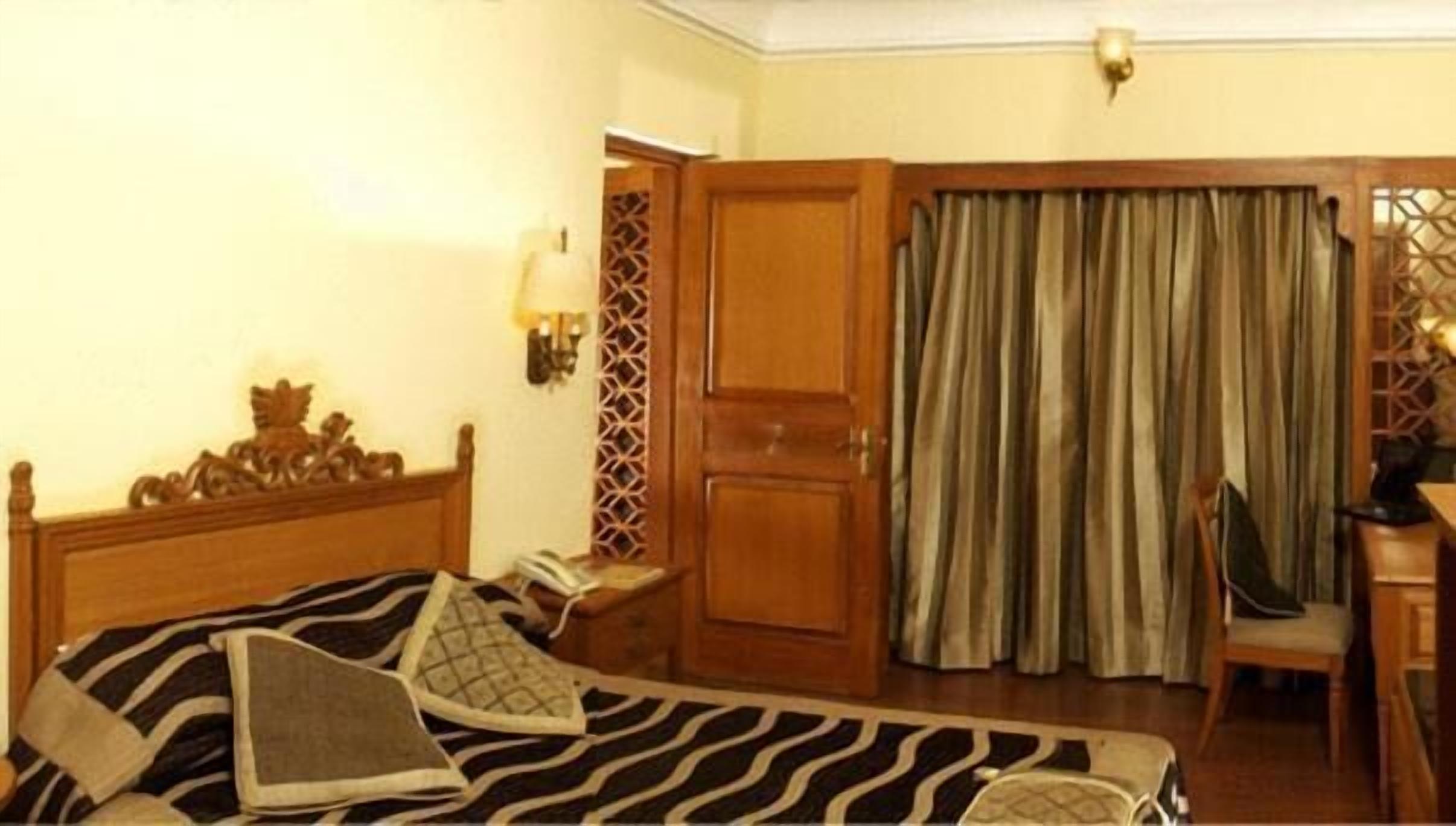 A hotel room with a bed, a desk, and a chair.