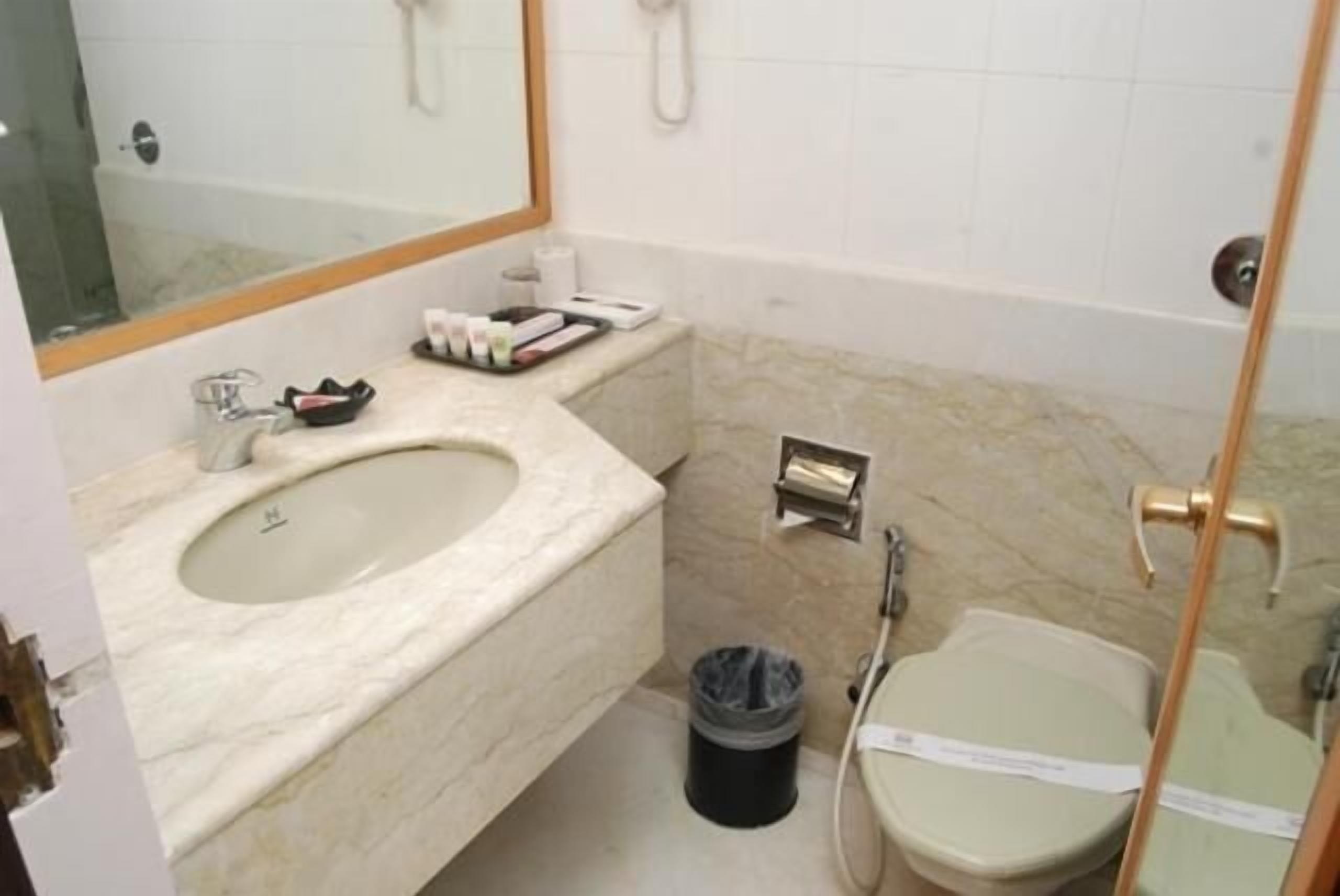 Une salle de bain avec un lavabo en marbre, des toilettes et une douche.