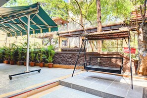 Un espacio al aire libre cubierto con una hamaca, un monopatín y macetas con plantas.