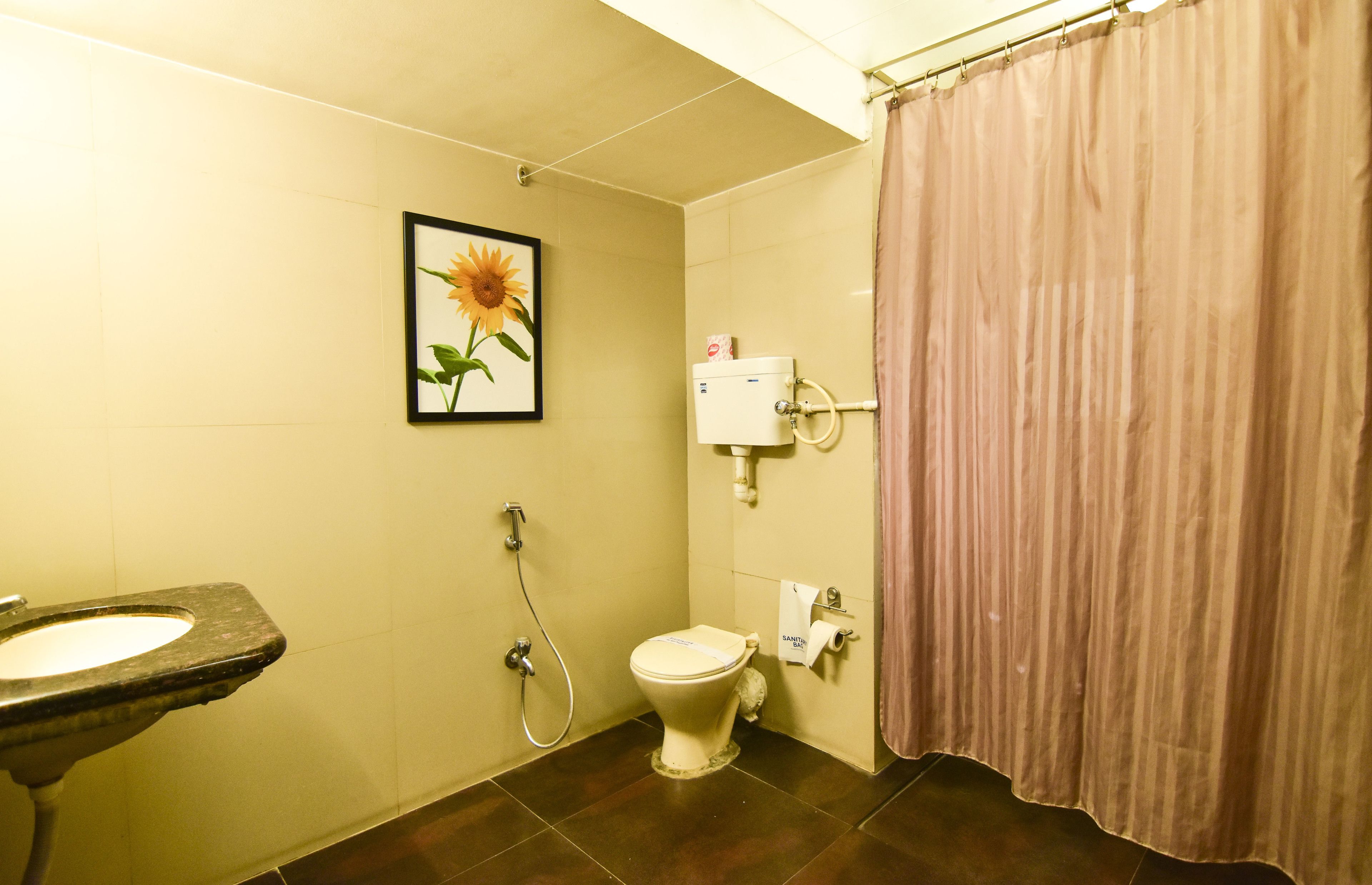 Een badkamer met toilet, wastafel en douchegordijn.