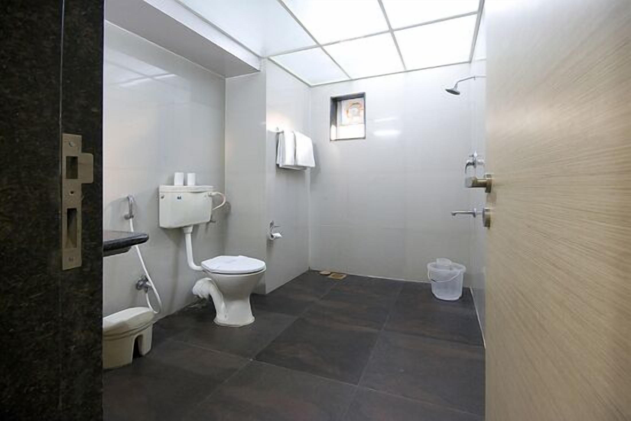 A small, modern bathroom with a toilet, sink, and shower.