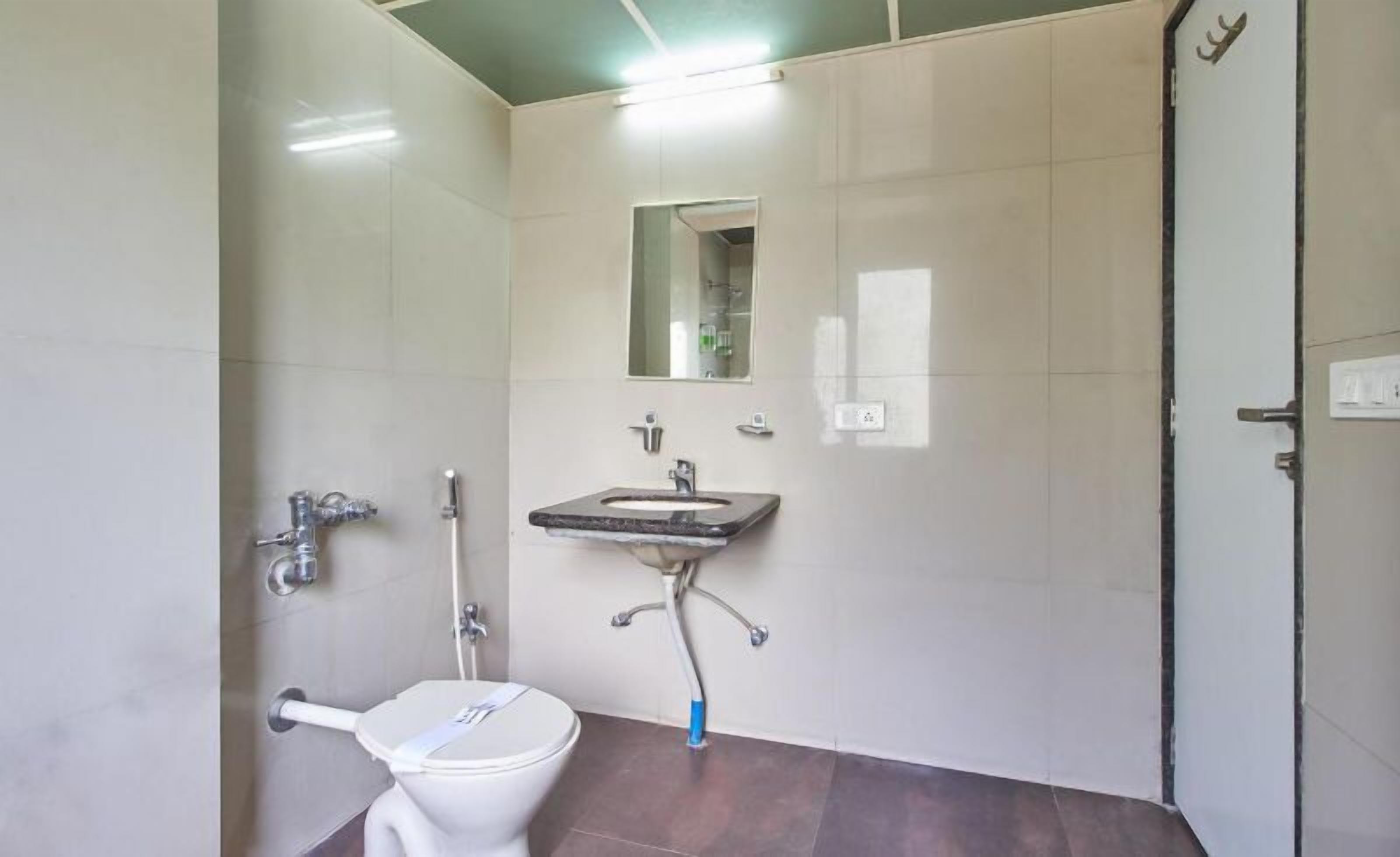 Un baño pequeño con inodoro, lavamanos y espejo.
