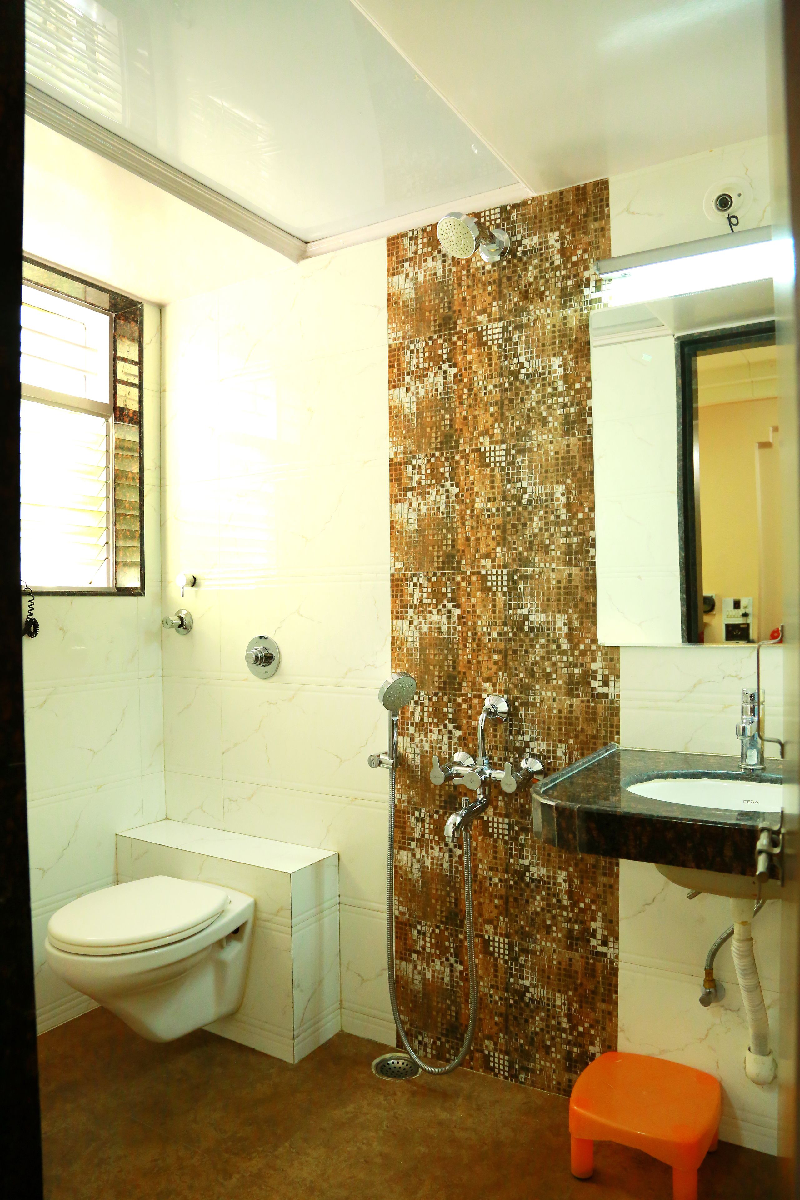 A bathroom with a toilet, shower, and sink.