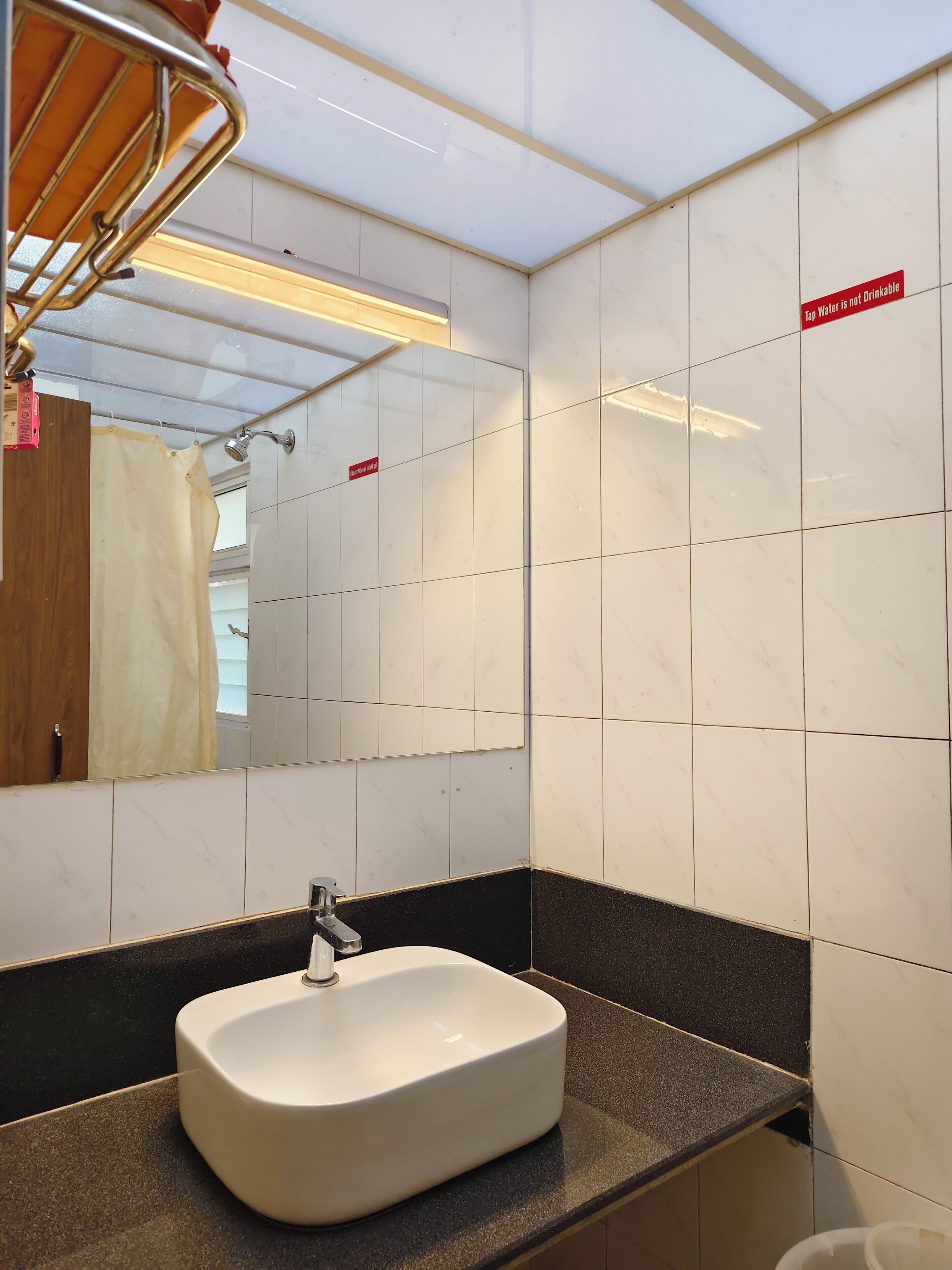 A bathroom with a white sink, black countertop, and a mirror.