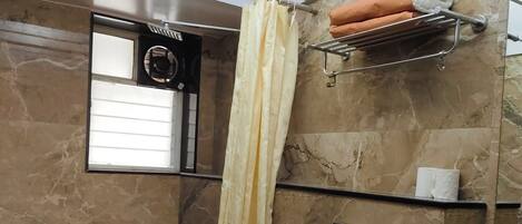 Un baño con inodoro, ducha y lavamanos.