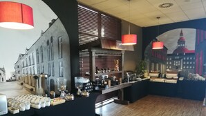 A café with a rustic interior, featuring a wooden floor, a counter with various food items, and a mural of a cityscape on the wall. - Quality Silesian Hotel (Katowice)