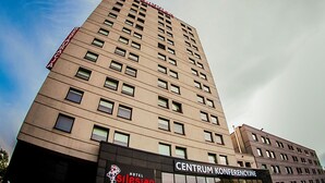 A tall hotel building with multiple floors, a visible sign for 'Hotel Silesian' at the base, and a clear sky in the background. - Quality Silesian Hotel (Katowice)