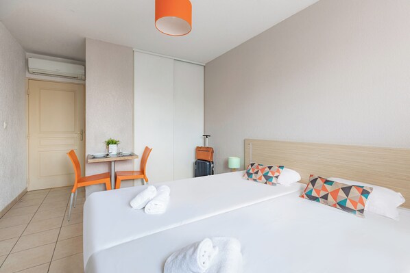 Una habitación de hotel con una cama, un escritorio y una silla.