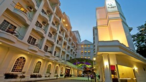 Un hôtel à plusieurs étages doté d’un atrium central, de balcons et d’une tour imposante sur laquelle est apposée une enseigne.