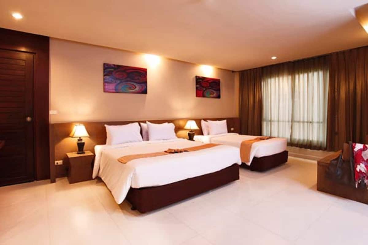 A hotel room with two beds, a desk, and a chair. There are two lamps on the nightstands, and the room has a large window with curtains.