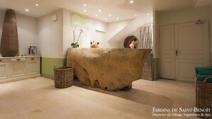 Una zona de recepción con un amplio mostrador de piedra, cestas de mimbre y un muro decorativo.