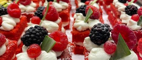 A display of red velvet desserts topped with cream and berries.
