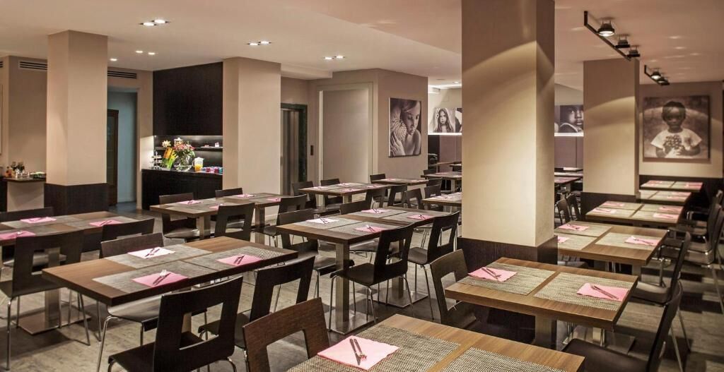 A restaurant with multiple tables and chairs, arranged in a spacious layout.
