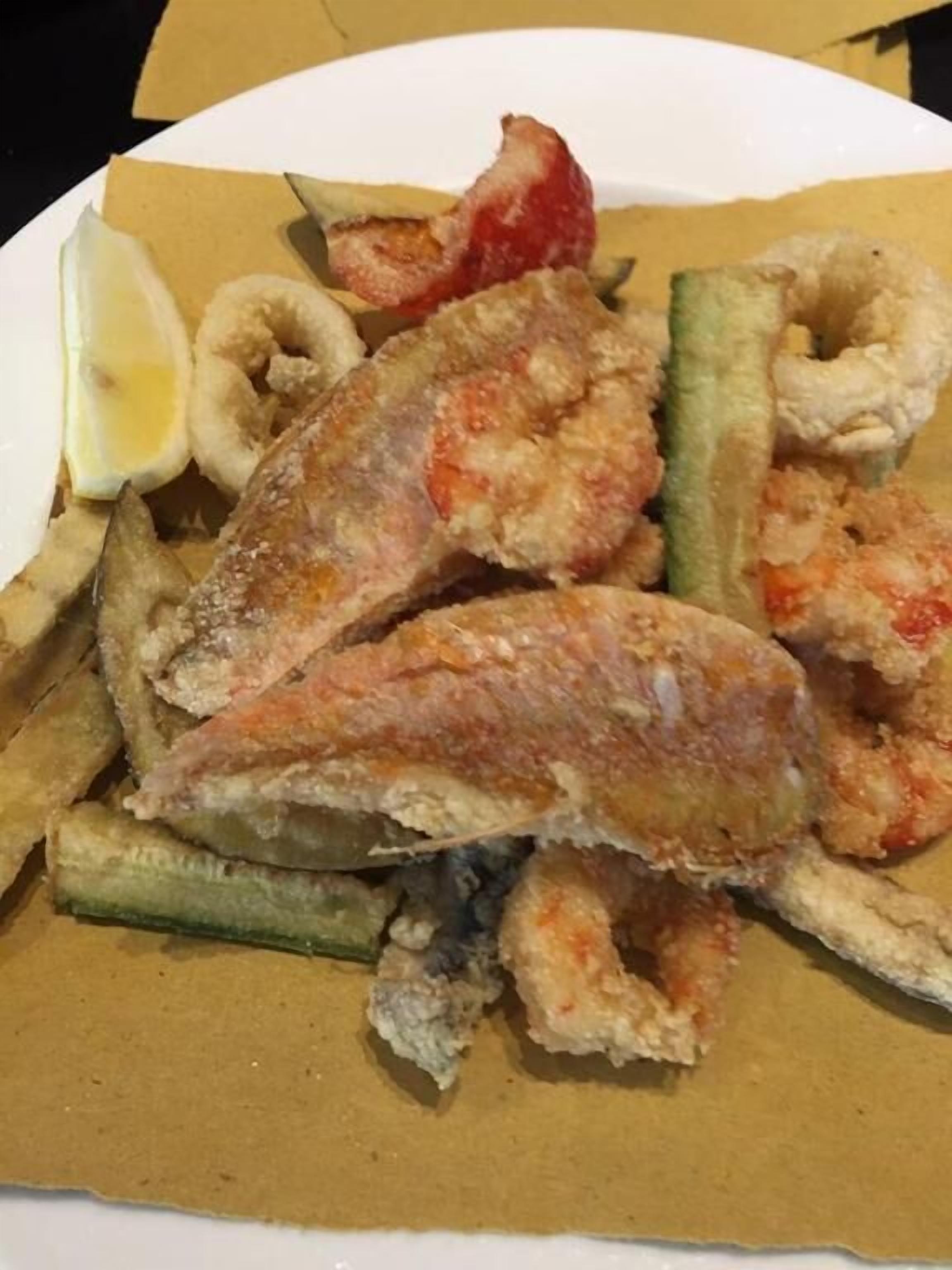 A plate of battered fish, chips, and onion rings.