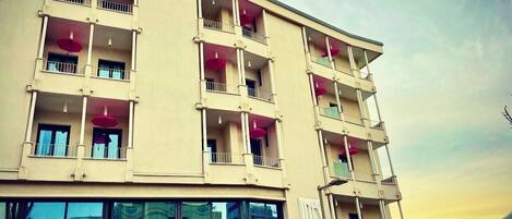 Un edificio de varios pisos con balcones, ventanas grandes y techo plano.