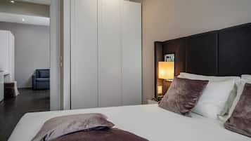 A hotel room with a large bed, a wardrobe, a desk, and a chair.