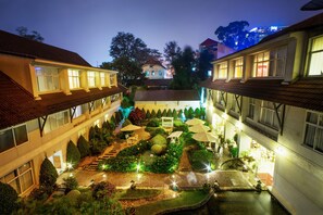 A courtyard with a central garden, steps leading to a building entrance, and a water feature. - Muong Thanh Da Lat (Xuan Huong - Da Lat)