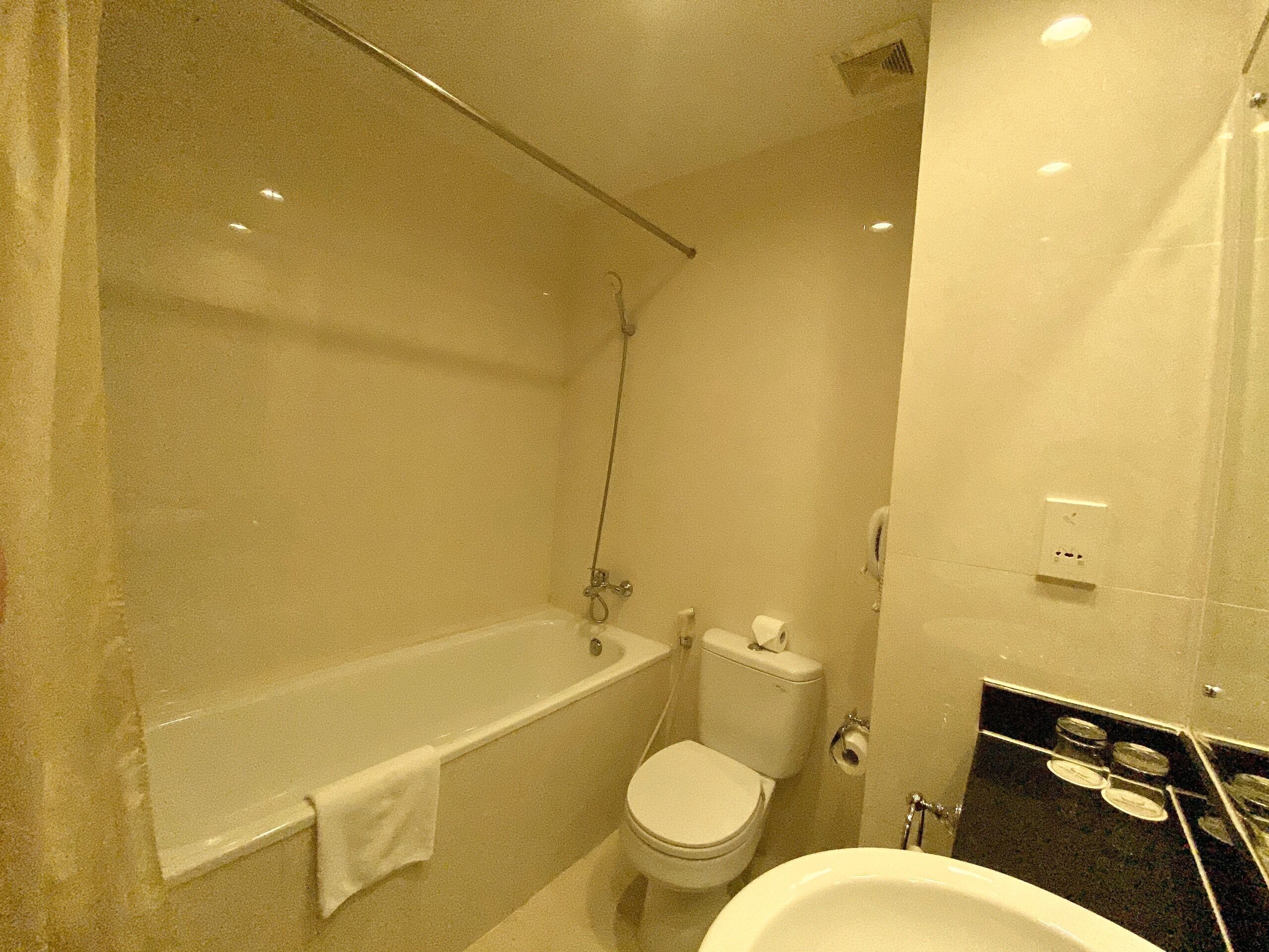 A bathroom with a bathtub, toilet, and sink.