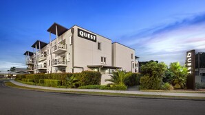 Ein modernes, mehrgeschossiges Gebäude, auf dessen Fassade der Name 'QUEST' gut sichtbar angebracht ist.