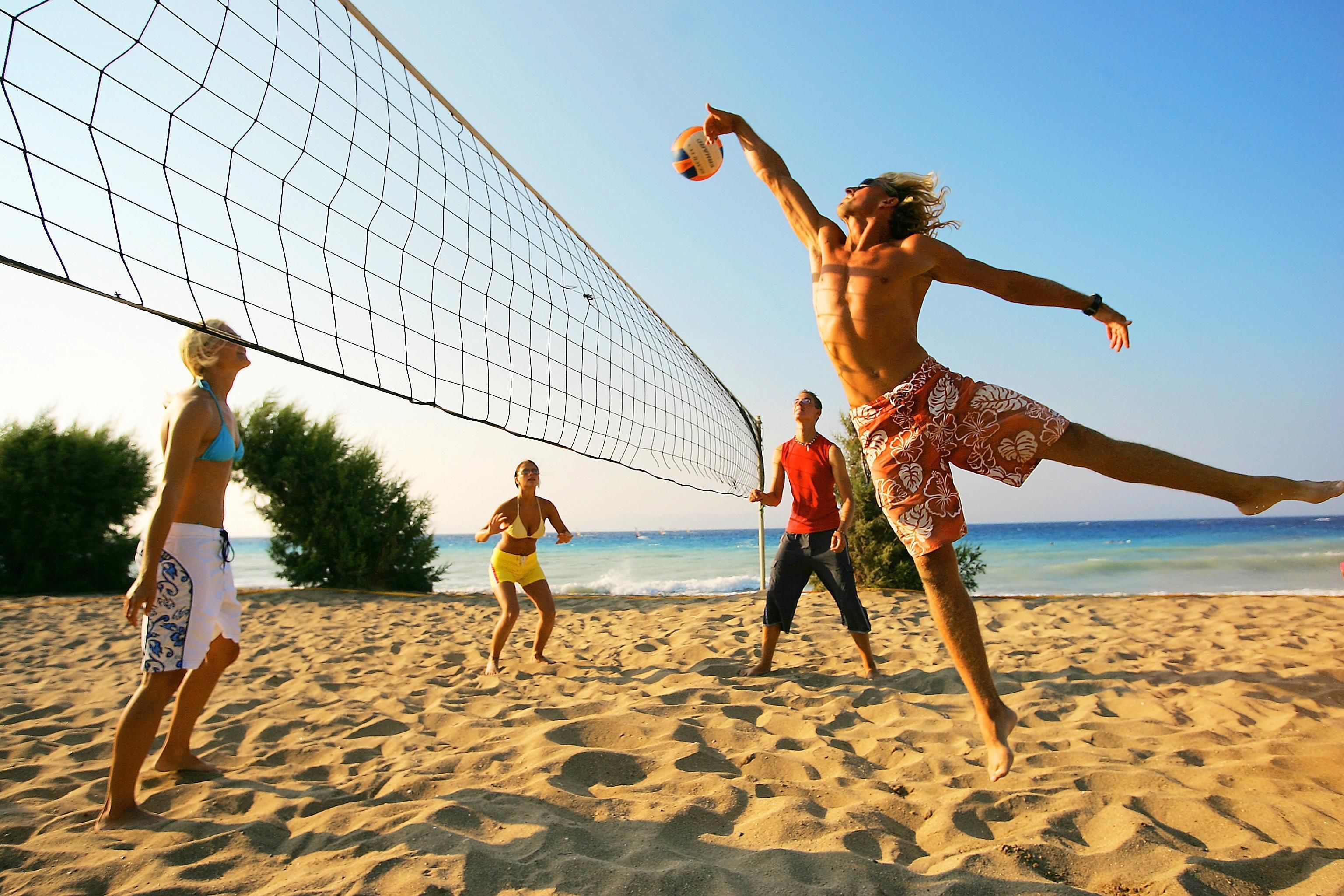 Ein Beachvolleyballspiel mit Spielern in leger Strandkleidung.