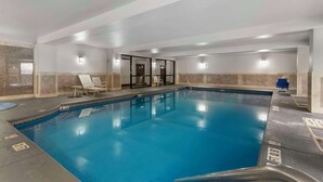 An indoor swimming pool with clear water, lounge chairs, and a tiled wall. - Comfort Suites Atlanta Airport (Atlanta)