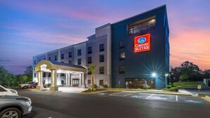 A Comfort Suites hotel with a modern design, featuring a large entrance and a parking area. - Comfort Suites Atlanta Airport (Atlanta)
