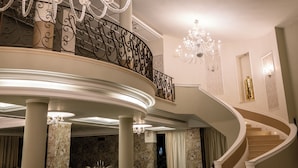 A grand staircase with a curved design, ornate railings, and multiple chandeliers. - Marina Holiday Hotel & Spa (Balestrate)