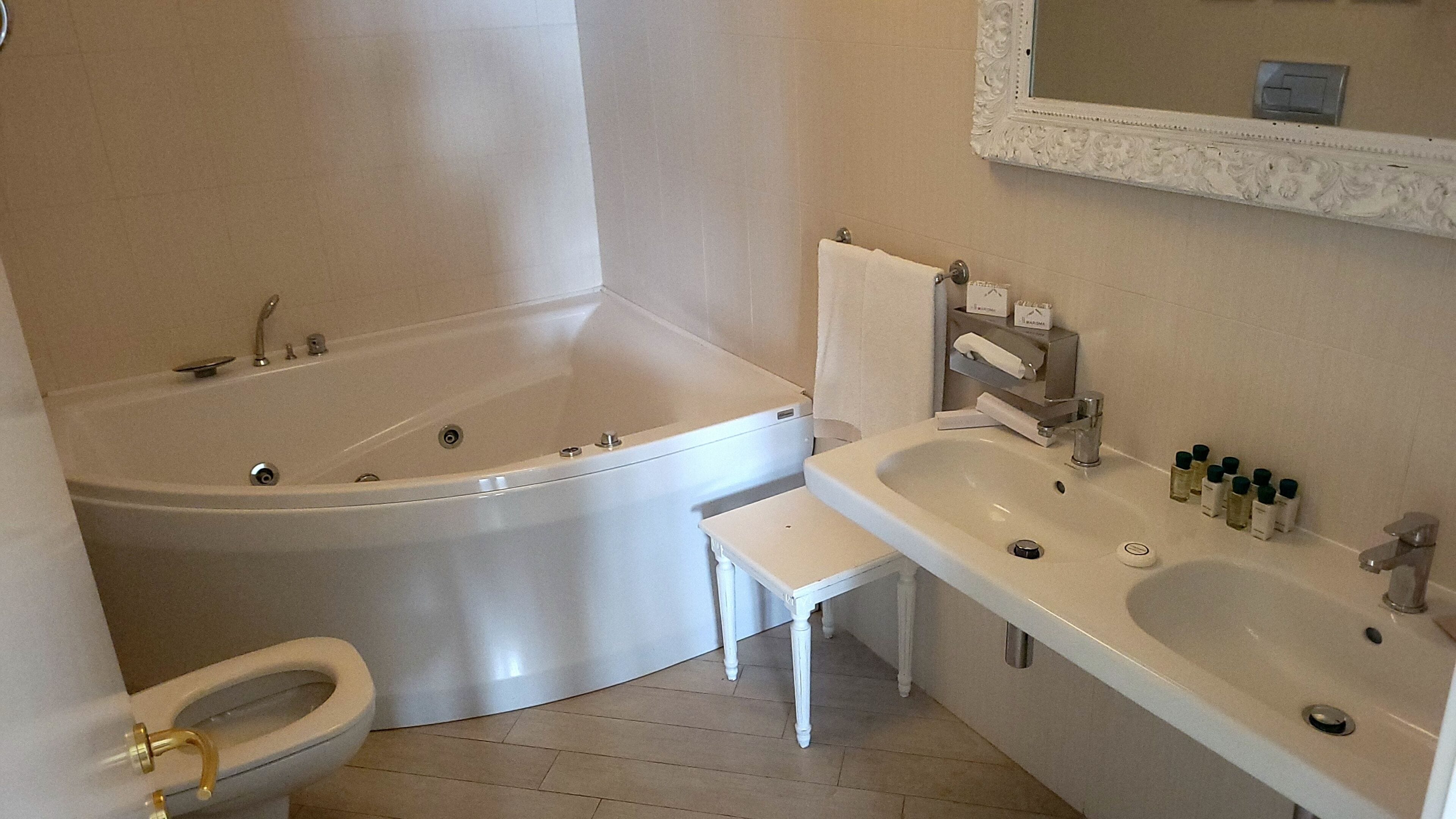 Ein Badezimmer mit Badewanne, Toilette, Waschbecken und Spiegel.