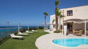 A pool area with lounge chairs, a covered seating area, and a view of the ocean. - Marina Holiday Hotel & Spa  (Balestrate)