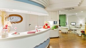 A hotel reception area with a curved counter, a sign reading "Hotel City," and a television screen in the background. - Hotel City (Montesilvano)
