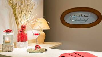 Un espace d’accueil d’hôtel comprenant un comptoir de réception, une lampe, des objets décoratifs et un panneau indiquant « Hôtel Kitty ».