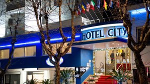 A hotel with a prominent "HOTEL CITY" sign, outdoor seating area, and a staircase leading to the entrance. - Hotel City (Montesilvano)