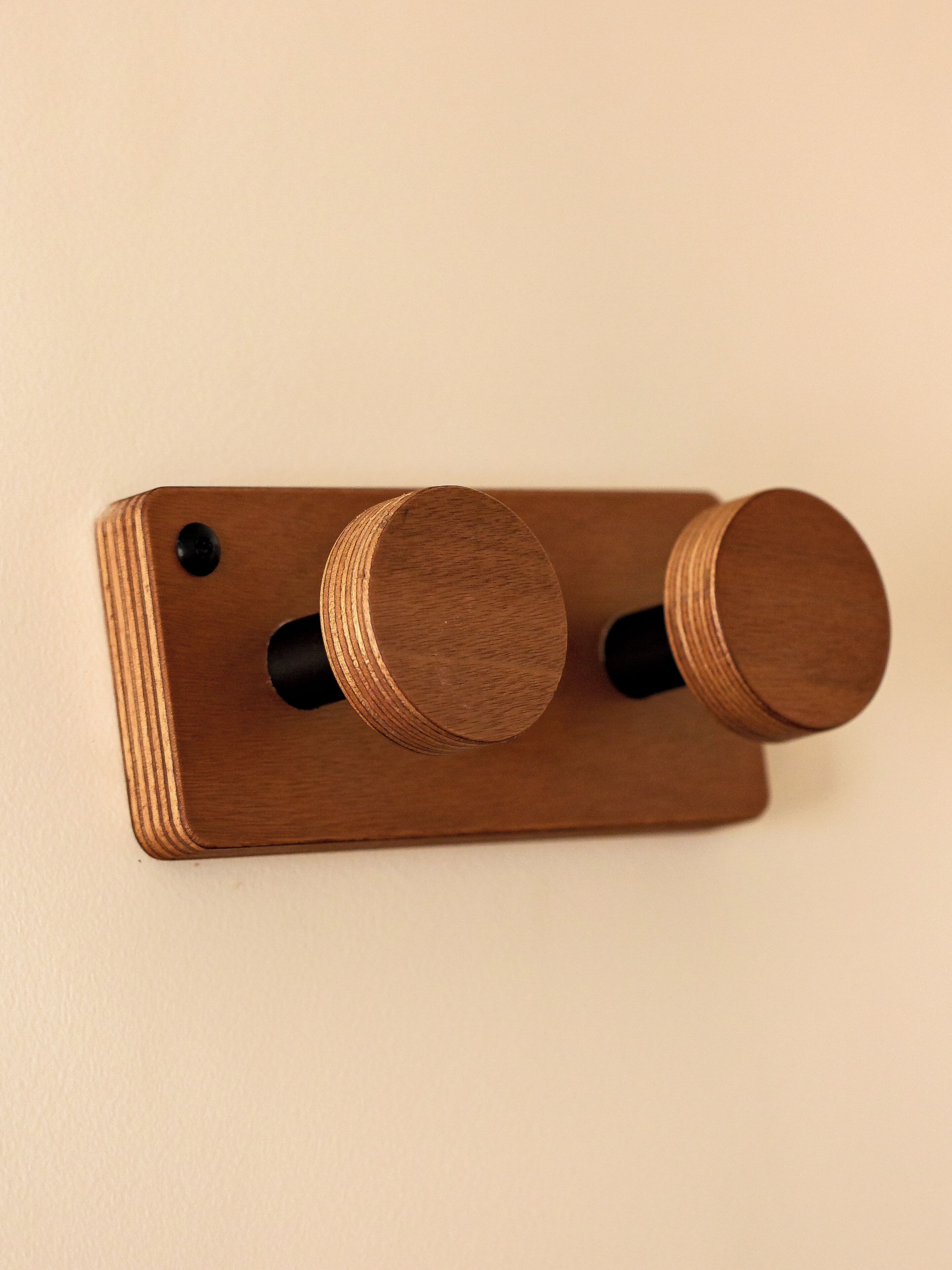 Eine an einer Holzwand befestigte Schalterleiste mit zwei runden Drehreglern.