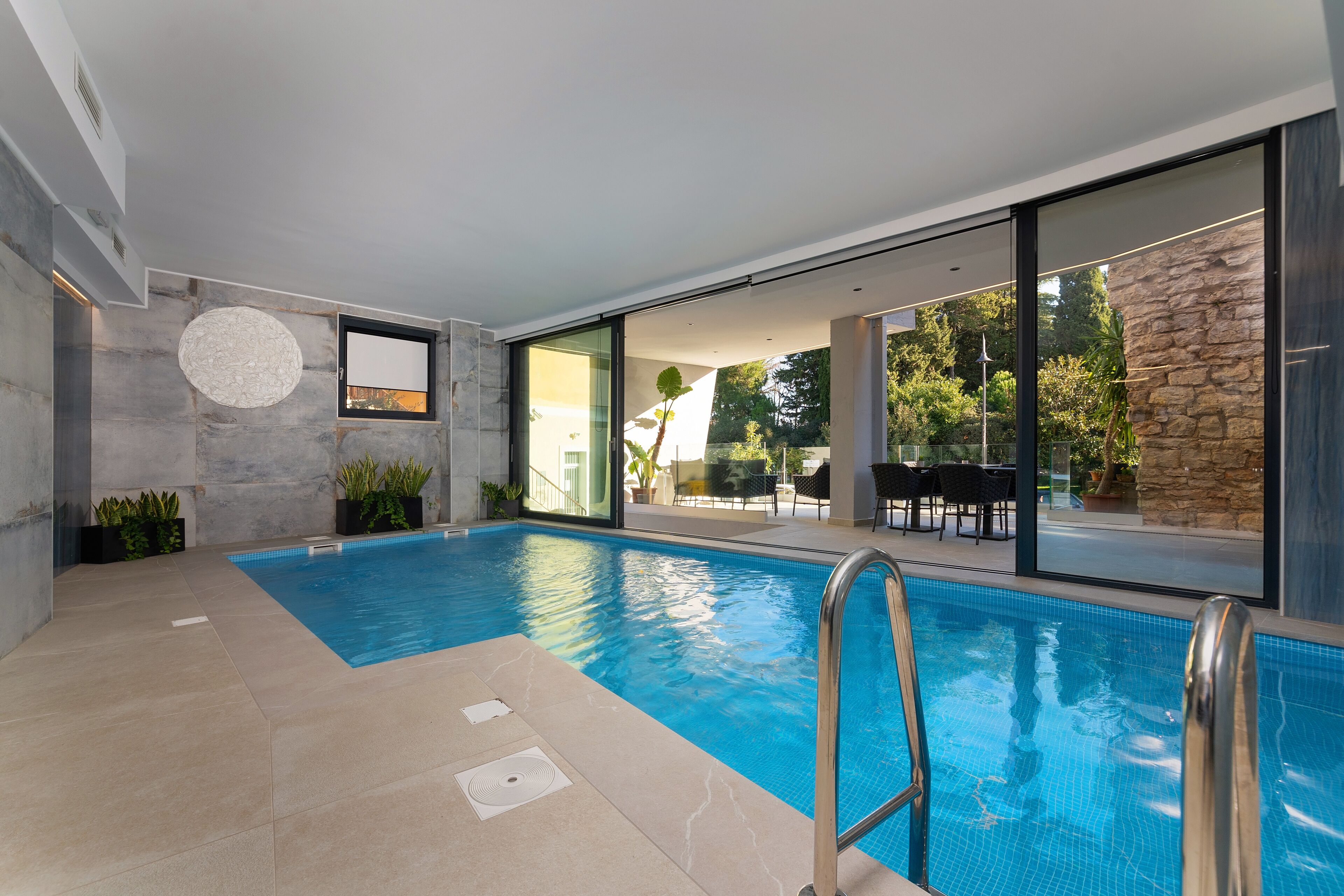 Una piscina techada, sillones reclinables de piscina