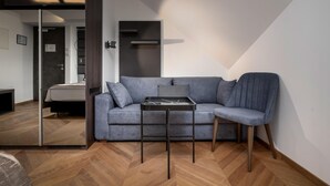 A modern living room with a grey sofa, a small table, and a chair. - Hotel Cittar (Novigrad)