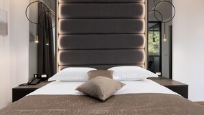 A modern hotel room with a large bed, a headboard, bedside tables, a phone, and a window with a view. - Hotel Cittar (Novigrad)