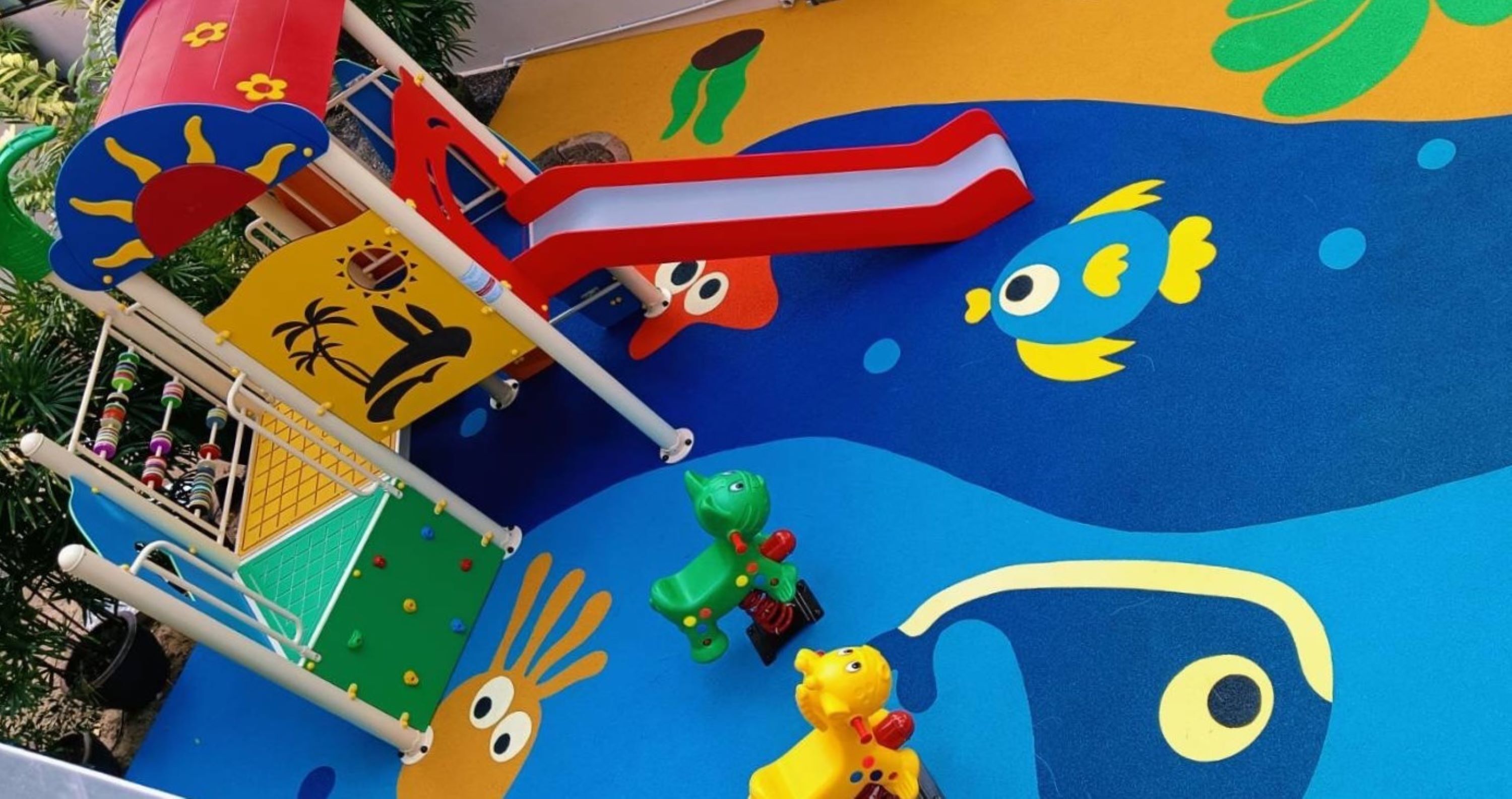 A colorful play area with a slide, climbing wall, and various play structures.