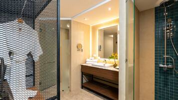 Un baño moderno con mampara de vidrio, lavamanos con espejo y zona de ducha.