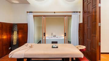 Relax in this serene spa room, featuring a massage table, bench, and sink.